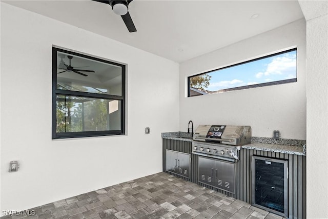 view of patio with grilling area, a sink, ceiling fan, exterior kitchen, and beverage cooler