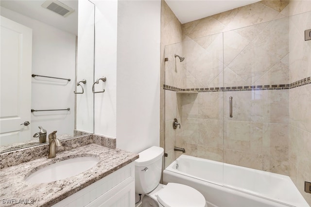 full bathroom with enclosed tub / shower combo, vanity, and toilet