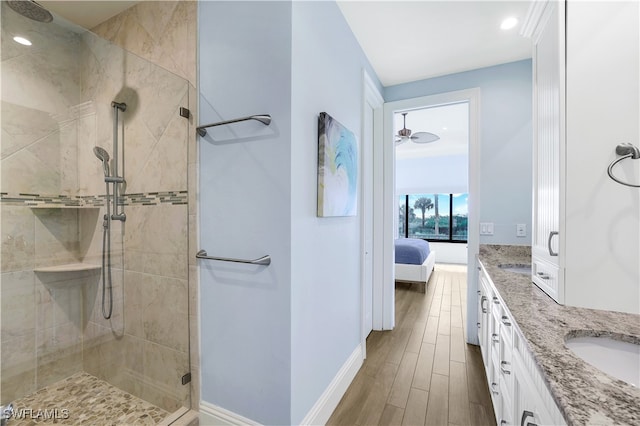 bathroom with walk in shower, wood-type flooring, and vanity