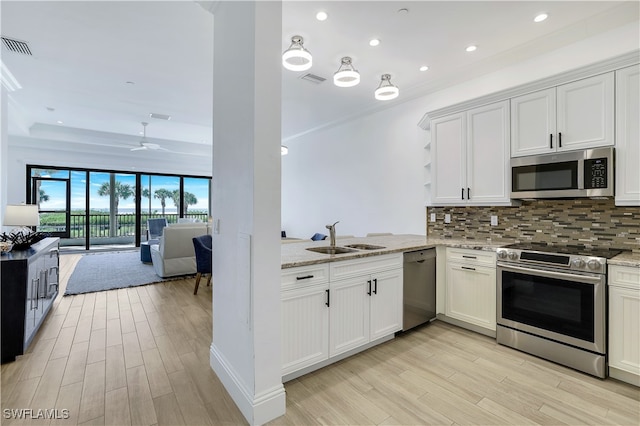 kitchen featuring stainless steel appliances, sink, white cabinets, ceiling fan, and light hardwood / wood-style flooring