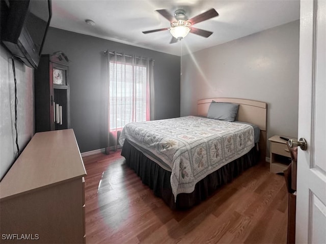 bedroom with dark hardwood / wood-style floors and ceiling fan