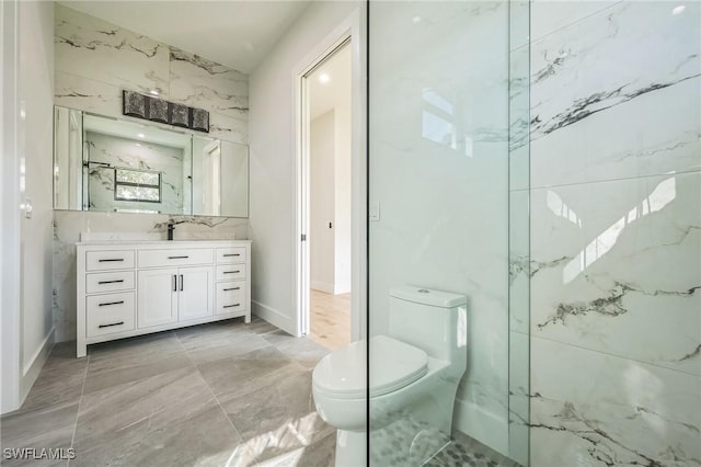 bathroom with vanity, toilet, and tile walls