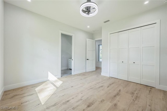 unfurnished bedroom featuring a closet and light hardwood / wood-style flooring