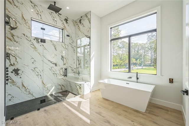 bathroom featuring hardwood / wood-style flooring, shower with separate bathtub, and a healthy amount of sunlight