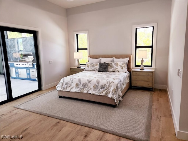 bedroom featuring access to exterior and light wood-type flooring