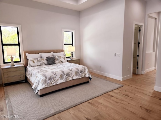 bedroom featuring multiple windows and light wood-type flooring