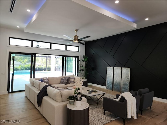 living room with ceiling fan and light hardwood / wood-style flooring