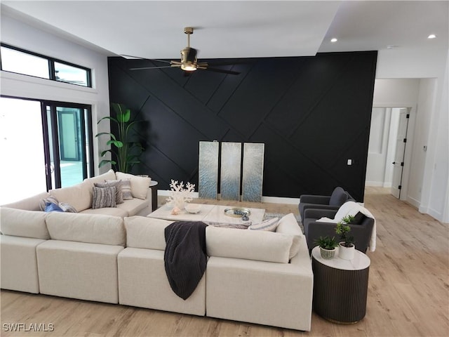 living room with ceiling fan and light wood-type flooring