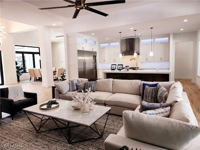 living room featuring ceiling fan and light hardwood / wood-style flooring