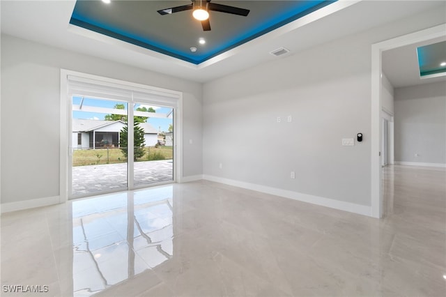 unfurnished room featuring a tray ceiling and ceiling fan