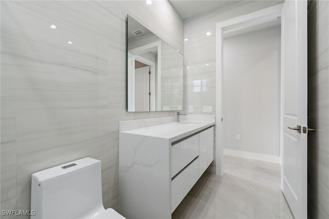 bathroom featuring vanity, toilet, and tile walls