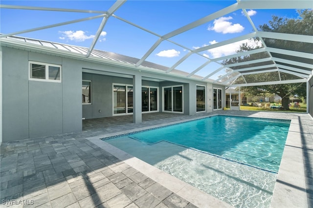 view of pool with glass enclosure and a patio