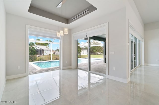 doorway to outside with a chandelier and a tray ceiling