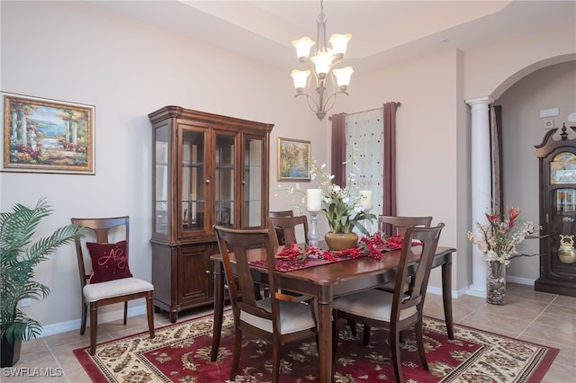 dining room featuring ornate columns, a notable chandelier, and light tile patterned floors