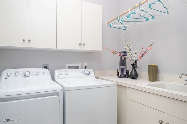 washroom featuring cabinets, sink, and independent washer and dryer