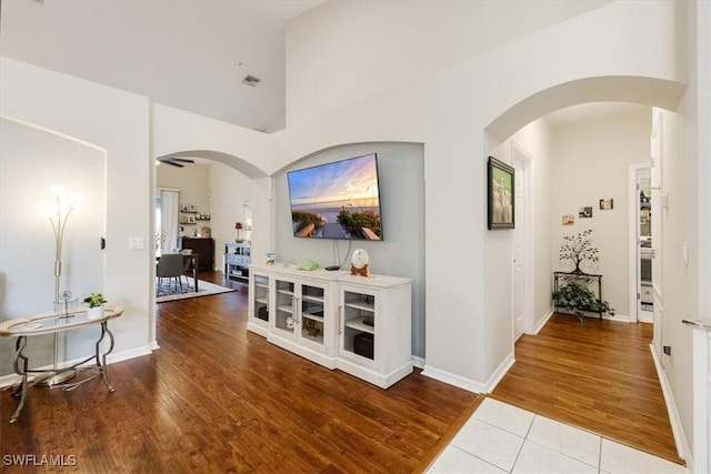 hallway with hardwood / wood-style floors and a high ceiling