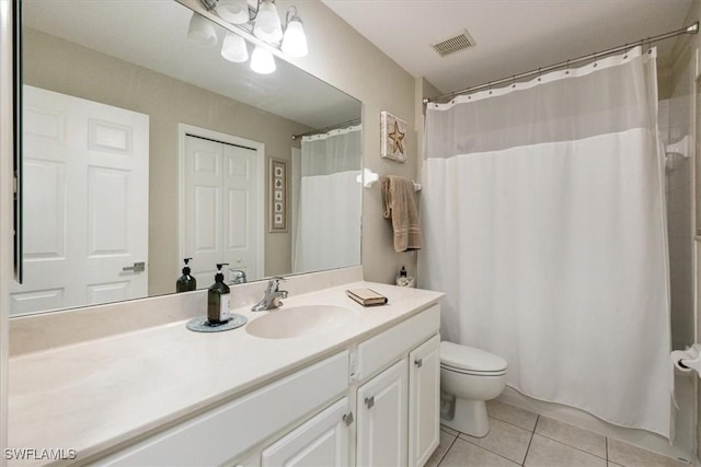 bathroom featuring toilet, vanity, tile patterned flooring, and walk in shower