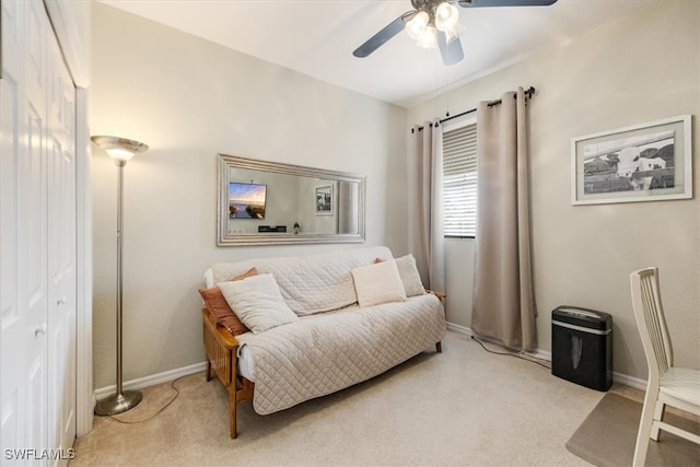 living area with light carpet and ceiling fan