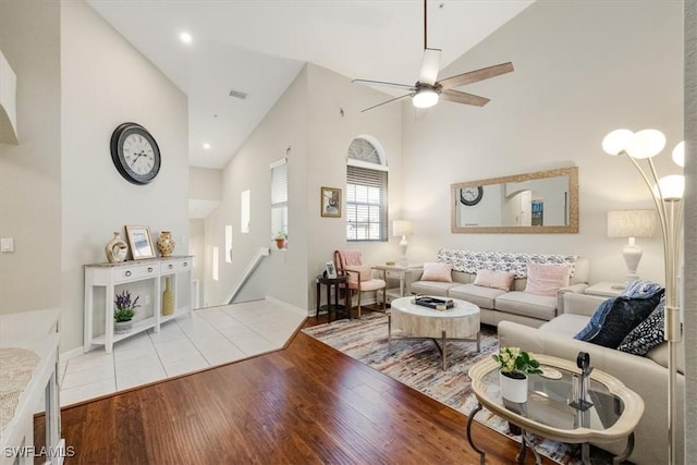 living room with high vaulted ceiling, ceiling fan, and light hardwood / wood-style flooring