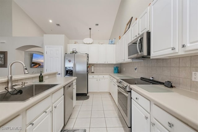 kitchen with stainless steel appliances, white cabinetry, lofted ceiling, and sink