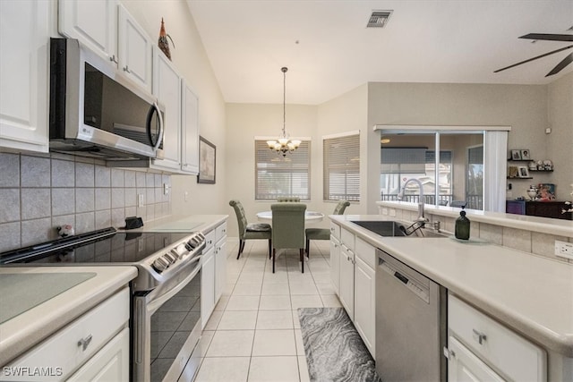 kitchen with pendant lighting, sink, light tile patterned floors, white cabinetry, and stainless steel appliances