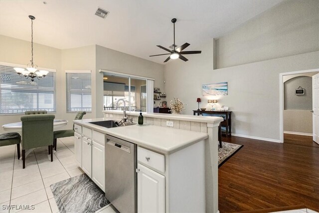 kitchen with white cabinetry, dishwasher, a kitchen island with sink, and light wood-type flooring