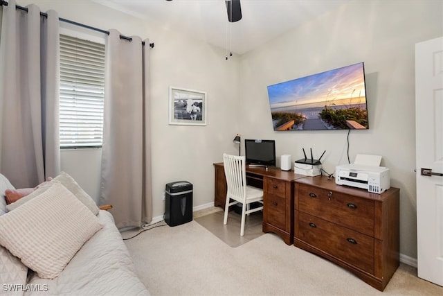 carpeted home office featuring ceiling fan