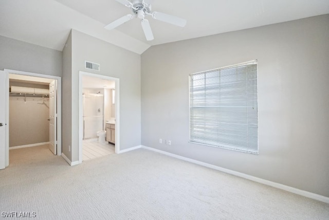4625 Saint Croix Ln Unit 1132, Naples, FL 34109 - unfurnished bedroom with light carpet, a spacious closet, vaulted ceiling, connected bathroom, and ceiling fan
