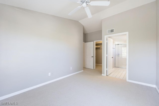 4625 Saint Croix Ln Unit 1132, Naples, FL 34109 - unfurnished bedroom with light carpet, lofted ceiling, a walk in closet, ensuite bath, and a ceiling fan