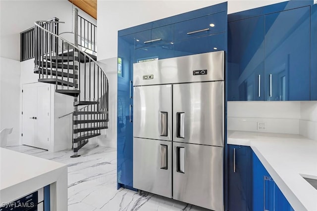 kitchen featuring stainless steel built in refrigerator and blue cabinets