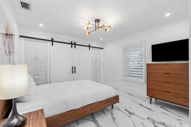 bedroom with a barn door and a notable chandelier