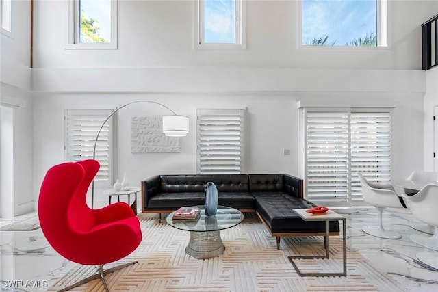 living room with a towering ceiling and a healthy amount of sunlight