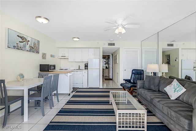 tiled living room featuring ceiling fan and sink