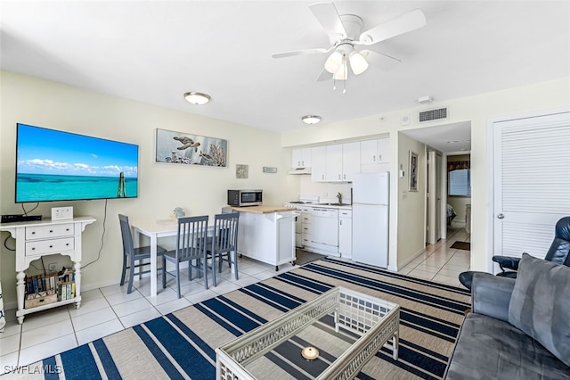 living room with ceiling fan, sink, and light tile patterned flooring