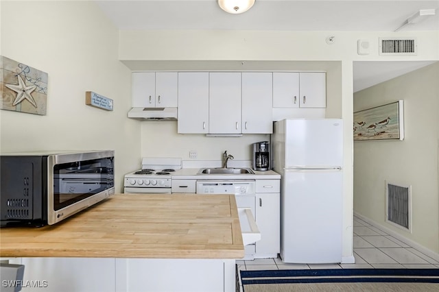 kitchen featuring light tile patterned floors, white appliances, white cabinetry, and sink