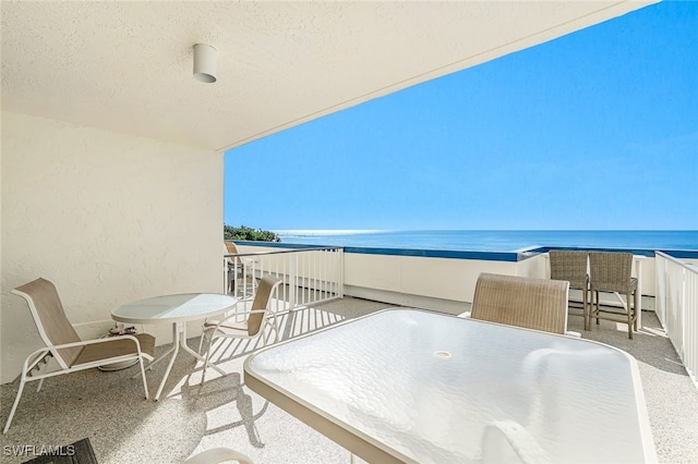 balcony featuring a water view and a baseboard heating unit