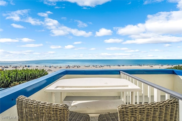 balcony with a water view and a view of the beach