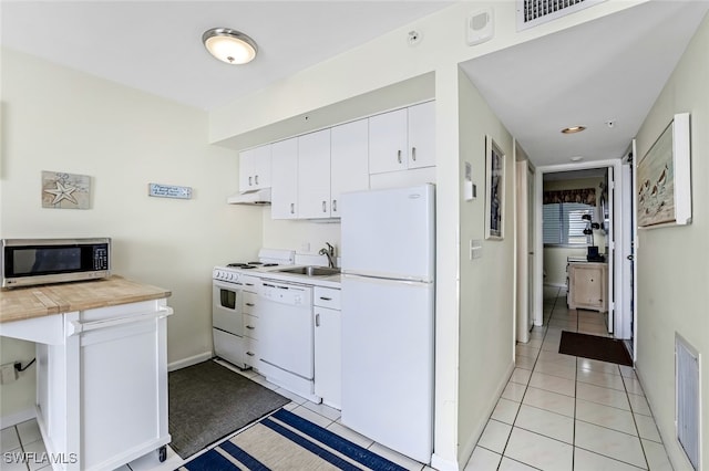 kitchen featuring white cabinets, light tile patterned floors, white appliances, and sink