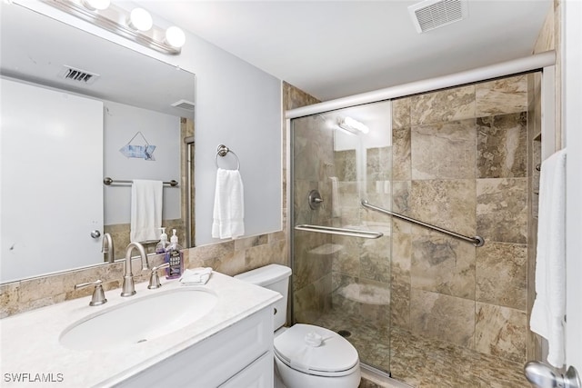 bathroom featuring an enclosed shower, vanity, and toilet