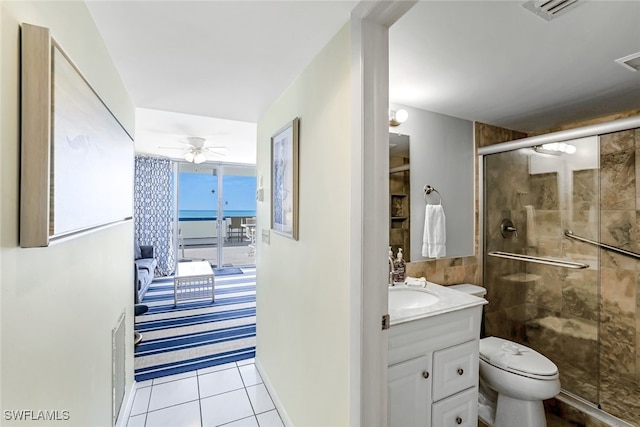 bathroom with toilet, tile patterned floors, a shower with door, vanity, and ceiling fan