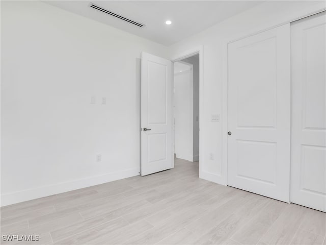 unfurnished bedroom with a closet and light hardwood / wood-style flooring