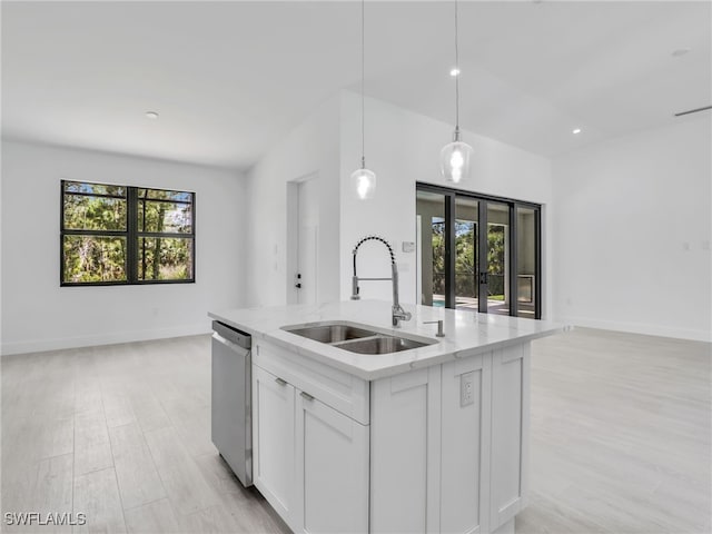 kitchen featuring dishwasher, decorative light fixtures, sink, and a wealth of natural light