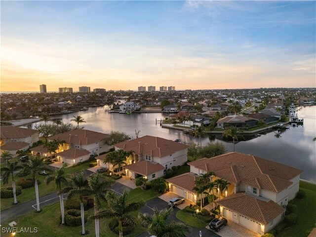 aerial view at dusk featuring a water view