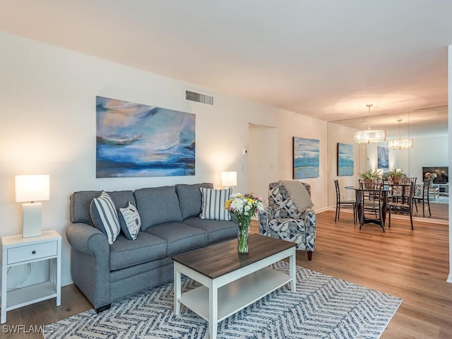 living room with hardwood / wood-style flooring and an inviting chandelier