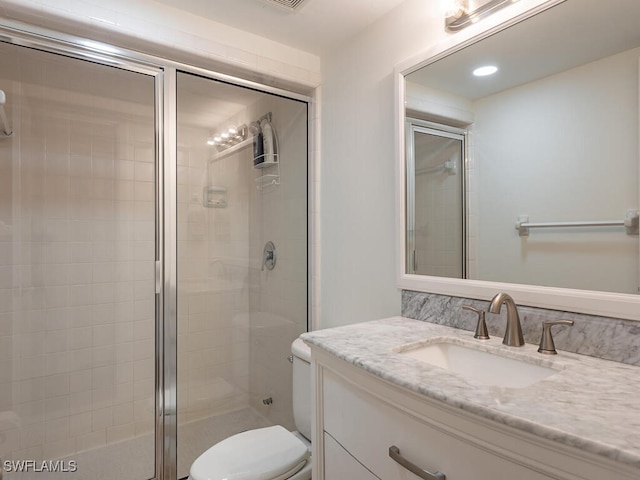 bathroom featuring walk in shower, vanity, and toilet