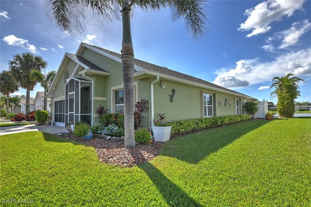 view of side of property featuring a sunroom and a yard