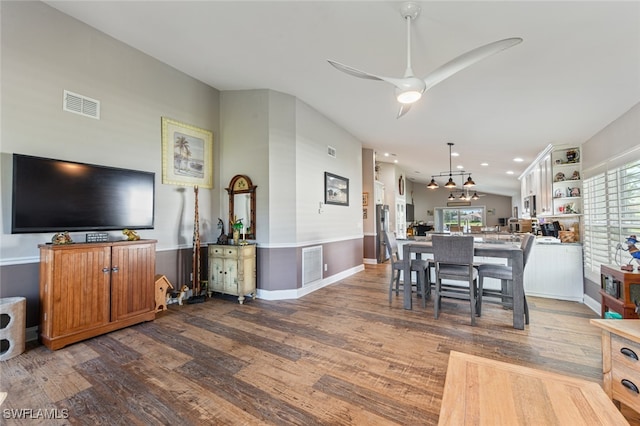 dining space with hardwood / wood-style flooring and ceiling fan with notable chandelier