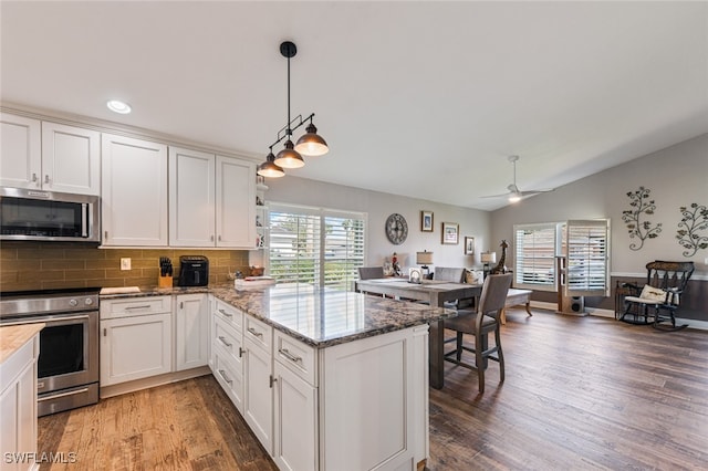 kitchen featuring white cabinetry, kitchen peninsula, stainless steel appliances, and dark hardwood / wood-style floors