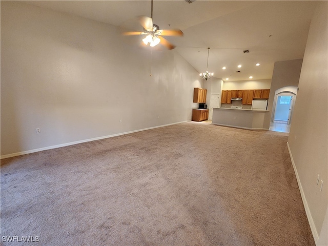 unfurnished living room featuring high vaulted ceiling, light colored carpet, and ceiling fan with notable chandelier