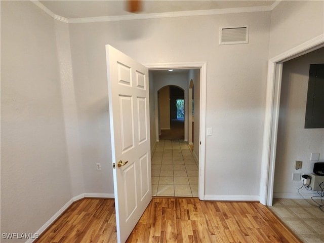 hallway featuring electric panel, light hardwood / wood-style flooring, and crown molding